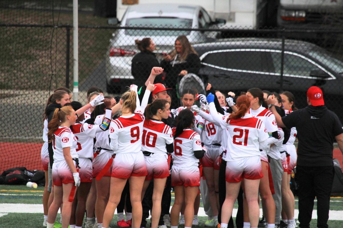 The East Islip Girls Flag Football team huddles up.